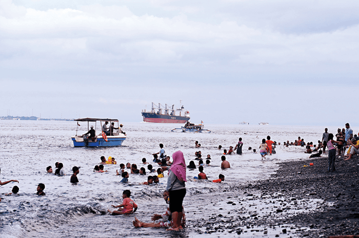 PENUH: Wisatawan memadati destinasi wisata di berbagai daerah di Jatim selama masa libur Lebaran. Termasuk di Pantai Watudodol, Banyuwangi. - Image