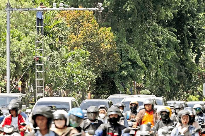 PENGAWAS LALU LINTAS: Petugas (kiri atas) melakukan perawatan rutin kamera pemantau lalu lintas di traffic light Kebun Binatang Surabaya. - Image