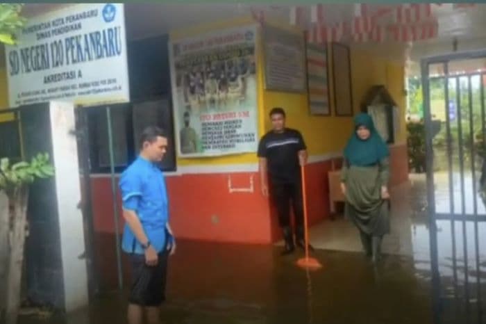 Kondisi SDN 120 Pekanbaru di Kelurahan Meranti Pandak tergenang banjir sehingga muridnya terpaksa belajar daring. - Image