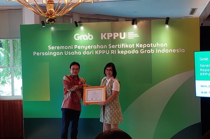 Wakil Ketua KPPU RI Aru Armando memberikan sertifikat kepada Country Managing Director, Grab Indonesia, Neneng Goenadi di Jakarta pada Senin (25/3). - Image