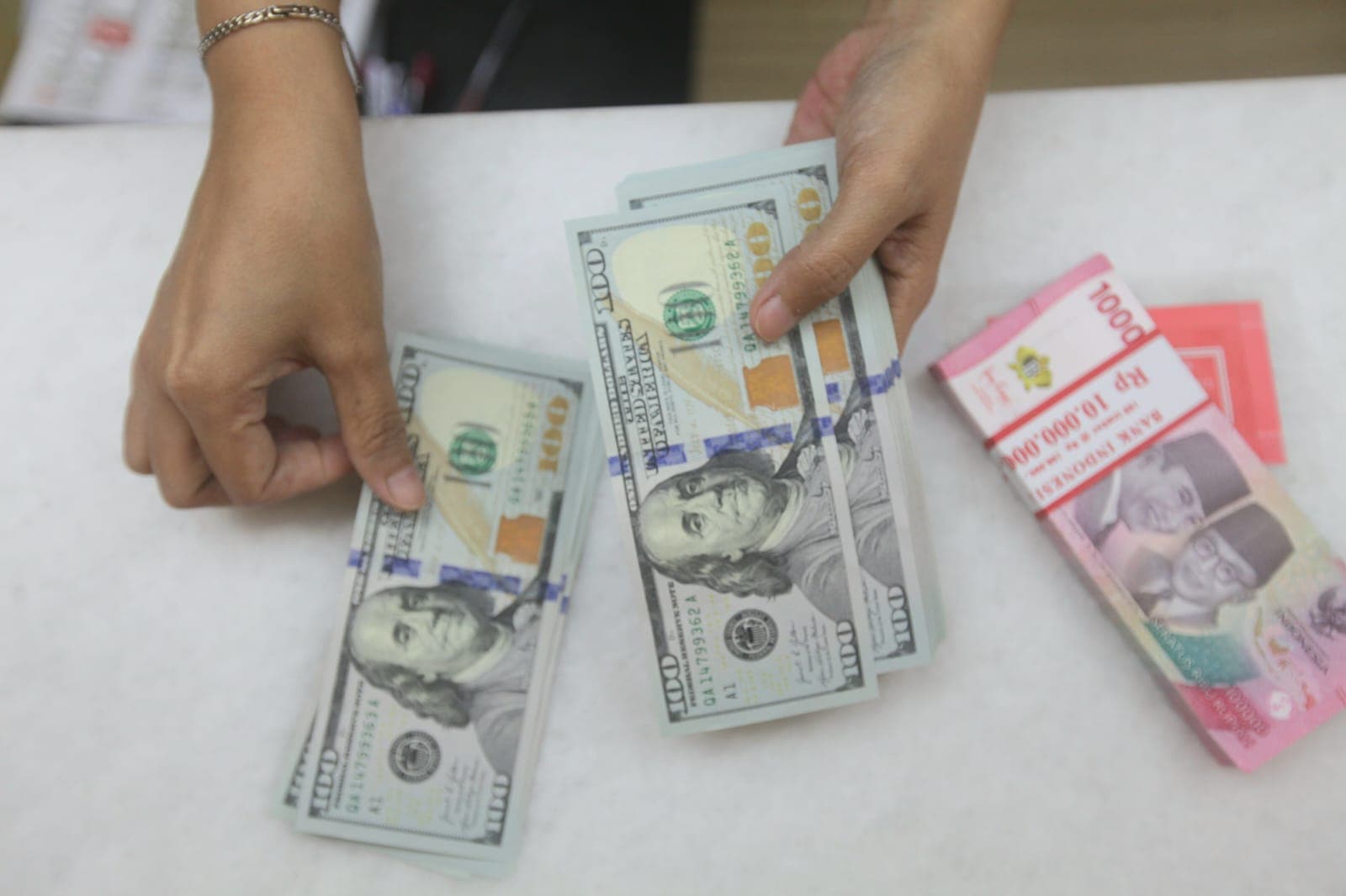 Petugas bank menyusun  lembaran uang rupiah dan dolar di salah satu bank di Jakarta. (Dery Ridwansah/ JawaPos.com) - Image