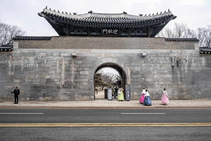 Pengunjung mengenakan hanbok tradisional berjalan melewati gerbang Yeongchumun di Istana Gyeongbokgung, Seoul, Korea Selatan. (The Korea Times) - Image