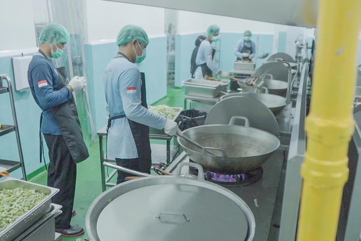 Ilustrasi: Petugas memasak makanan bergizi gratis menggunakan energi bersih. (Istimewa) - Image