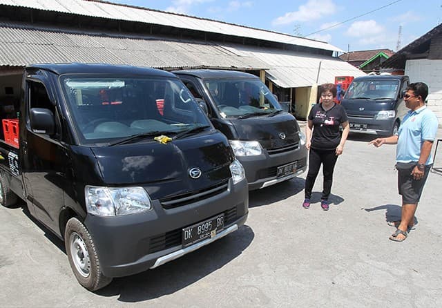PIMPIN PASAR: Irawati (dua dari kanan) berbincang dengan karyawannya di depan Daihatsu Gran Max Pick-Up di Desa Dangin Puri Kaja, Denpasar. (M. Ali/Jawa Pos) - Image