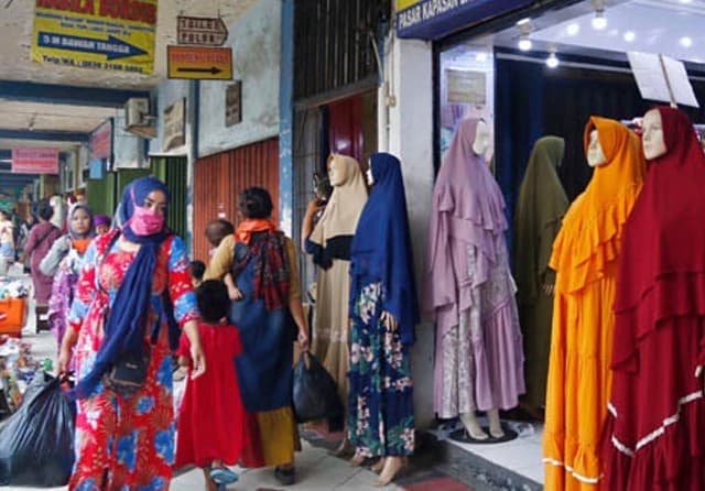 Pedagang di Pasar Kapasan bisa bernapas lega karena bisa kembali berjualan setelah 14 hari tak berjualan. (Ahmad Khusaini/Jawa Pos) - Image