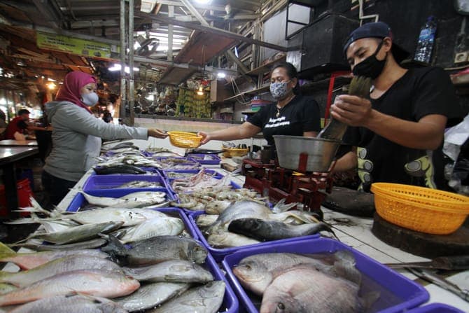 Pedagang ikan saat melayani pembeli di Pasar Tempel Pondok Labu, Jakarta, Selasa (6/7/2020).  Menteri Kelautan dan Perikanan, Edhy Prabowo, menyebut harga ikan baik di pasar maupun tempat pelelangan tengah turun. Pandemi covid-19 menjadi salah satu penyeb - Image