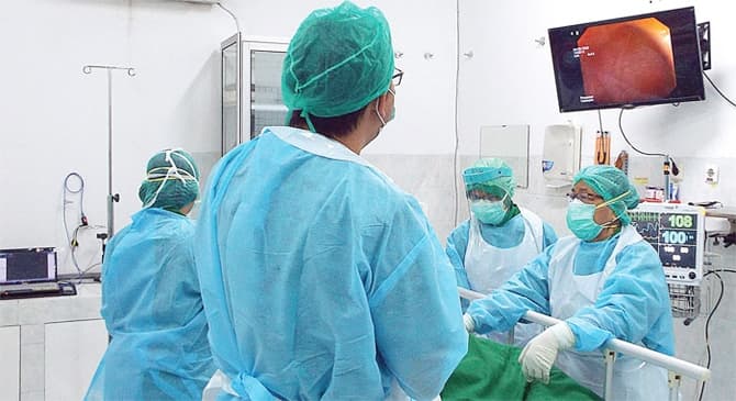 MEMADAI: Para dokter ahli di RS Darmo sedang menangani pasien GERD menggunakan metode kolonoskopi atau pemeriksaan endoskopi yang menggunakan selang lentur berkamera di bagian ujung. Selang yang masuk ke dalam tubuh itu dilengkapi sinar untuk memeriksa si - Image