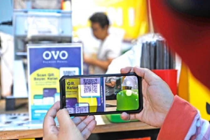 Ilustrasi pengguna uang elektronik OVO tengah melakukan transaksi online - Image