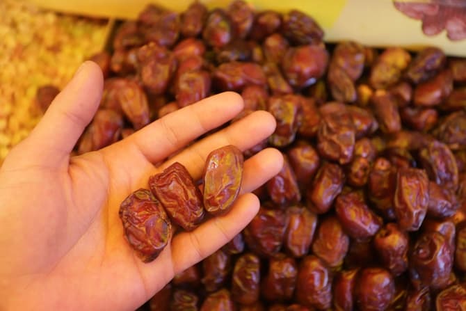 Seorang penjual kurma menata kurma di kiosnya, di Pasar Tanah Abang, Jakarta, Senin (22/3/2021). Jelang Bulan Ramadan, sejumlah pedagang di kawasan Tanah Abang mendadak alih profesi menjadi penjual kurma dadakan. Foto: Dery Ridwansah/ JawaPos.com - Image