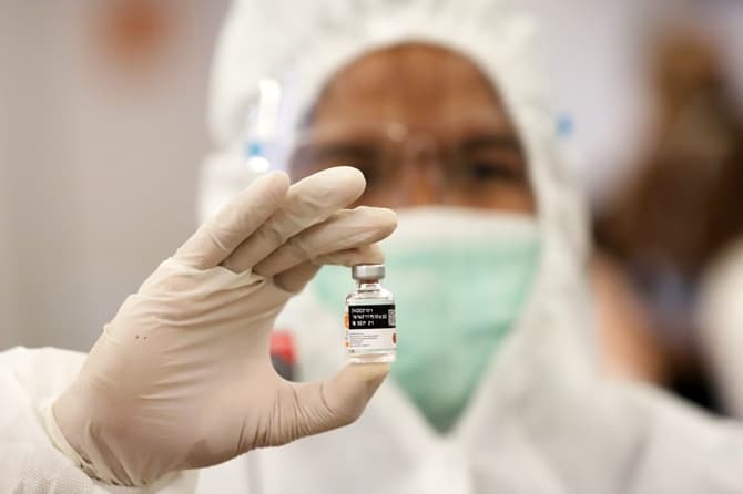 Tenaga medis saat menunjukan vaksin sebelum di suntikan kepada buruh dan pekerja di Kementerian Ketenagakerjaan, Jakarta, Selasa (4/5/2021). Vaksinasi massal yang dilakukan oleh Kementerian Ketenagakerjaan tersebut diikuti oleh 1.000 pekerja dan buruh, be - Image