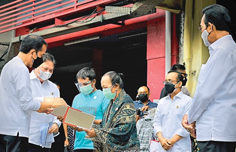 TERDAMPAK PANDEMI: Presiden Joko Widodo menyerahkan bantuan untuk pedagang  kaki lima dan warung di kawasan Malioboro, Jogjakarta, kemarin (9/10). (LAILY RACHEV/SETPRES) - Image