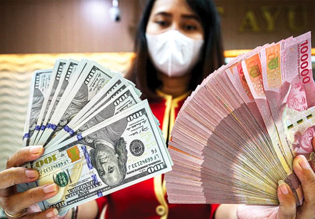 Karyawati menunjukkan uang rupiah dan USD di tempat penukaran uang Ayu Masagung, Jakarta. - Image