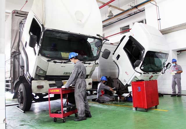 LAYANAN PURNA JUAL: Mekanik sedang melakukan cek rutin kendaraan di bengkel pusat Isuzu di Sunter, Jakarta,  Rabu (2/2).  (IAMI for JawaPos.com) - Image