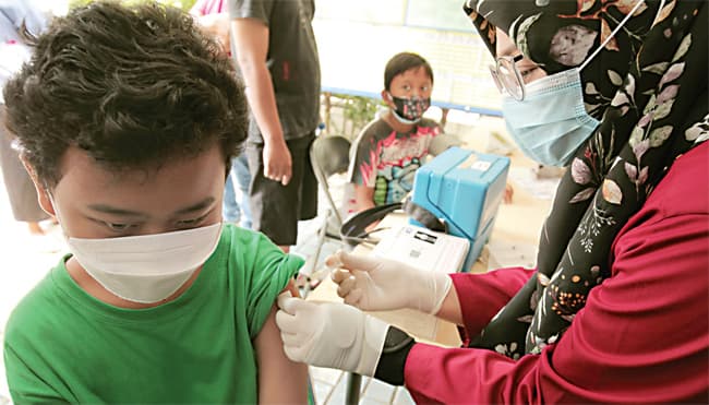 UNTUK IMUNITAS: Seorang anak disuntik vaksin Covid-19 di Sudimara Timur, Ciledug, Tangerang, kemarin (10/2). (MUHAMAD ALI/JAWA POS) - Image