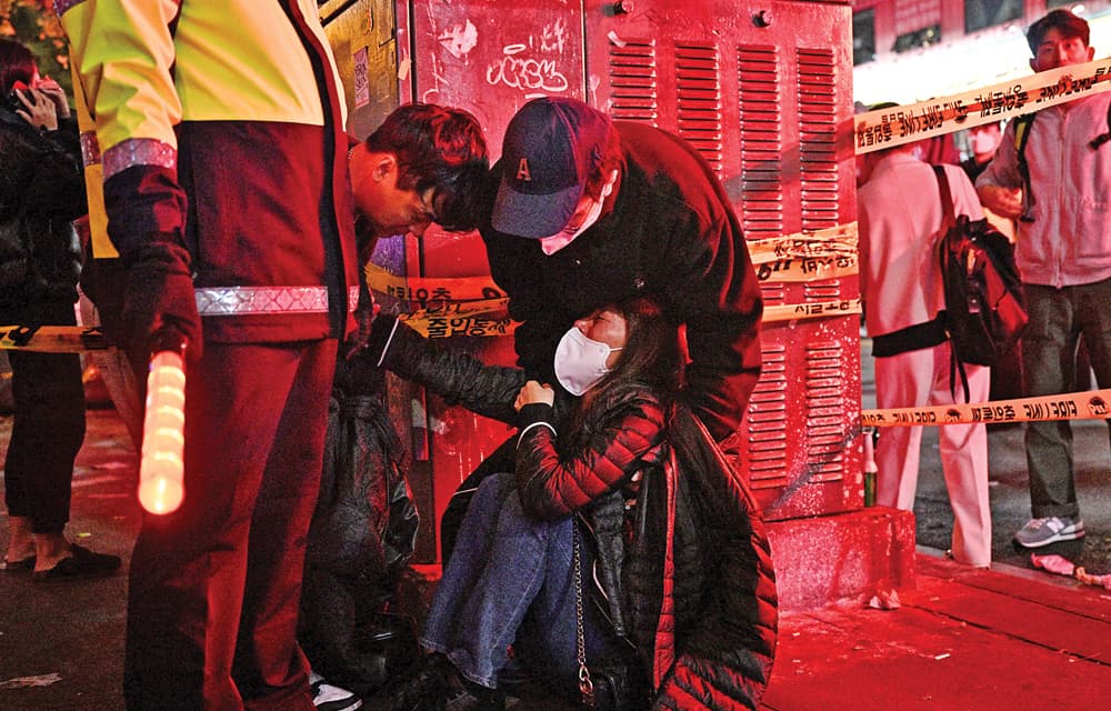 TRAGEDI HALLOWEEN: Seorang korban mendapat pertolongan di Itaewon, Seoul (30/10). Ratusan nyawa melayang dalam perayaan itu. (AFP) - Image