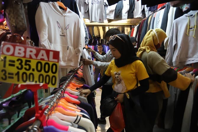 Calon pembeli memilih baju di pusat penjualan pakaian di Kabupaten Ciamis, Jawa Barat, Senin (19/5/2020). Meski sudah diterapkan Pembatasan Sosial Berskala Besar (PSBB) di Ibu Kota, namun menjelang lebaran toko pakaian ramai dikunjungi orang yang ingin me - Image