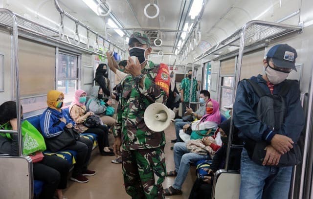 Petugas TNI memberikan imbauan jaga jarak penumpang KRL jarak fisik di Stasiun Manggarai, Jakarta, Kamis (28/5). Kedisiplinan protokol kesehatan di lingkungan KRL itu dilakukan menjelang diberlakukannya tatanan normal baru. FOTO: SALMAN TOYIBI/JAWA POS - Image