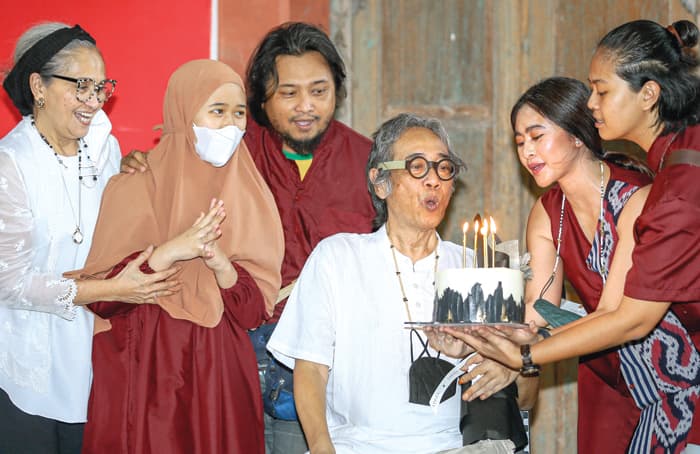 PERSEMBAHAN PARA SAHABAT: Butet Kartaredjasa, istri, dan putra-putri meniup lilin kue ulang tahun ke-60 saat peluncuran buku Urip Mung Mampir Ngguyu dan pameran lukisan Menawar Isyarat di Bale Banjar Sangkring, Bantul, tadi malam. (DIPTA WAHYU/JAWA POS) - Image